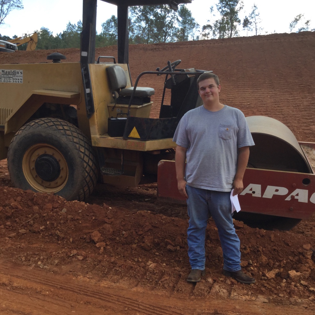 WBL student in front of roller on job site